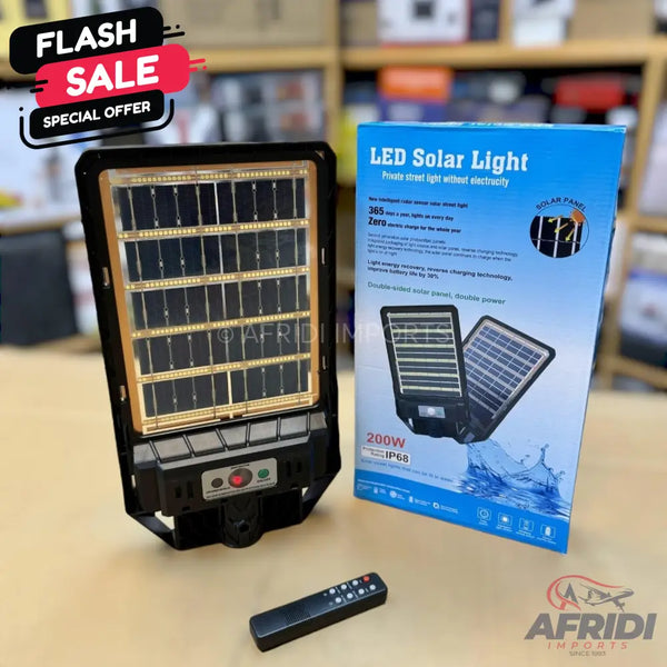 A black LED solar light with an integrated solar panel, a remote control, and a blue retail box.
