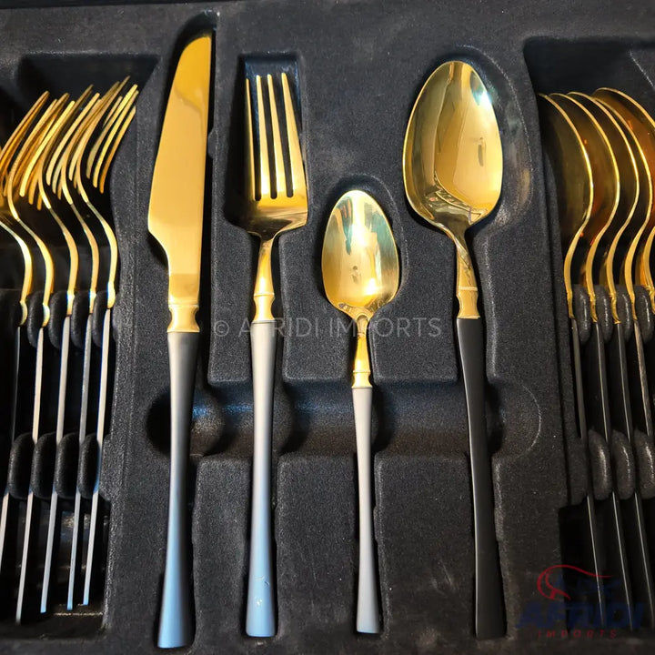Gold and black flatware set in a fitted tray.