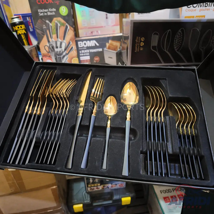 A black box containing a gold and black cutlery set with sleek handles.