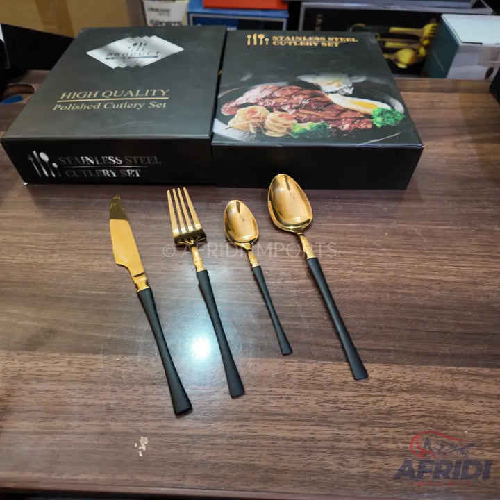 A four-piece set of gold and black polished stainless steel cutlery.