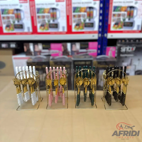 Four sets of gold-colored cutlery with white, pink, green, and black handles, each in a matching metal stand.
