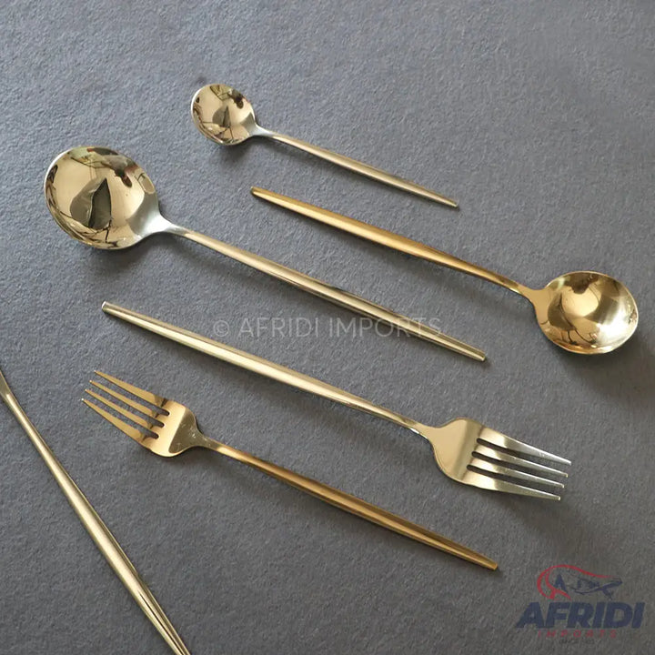 A set of modern gold-colored flatware, including spoons and forks.