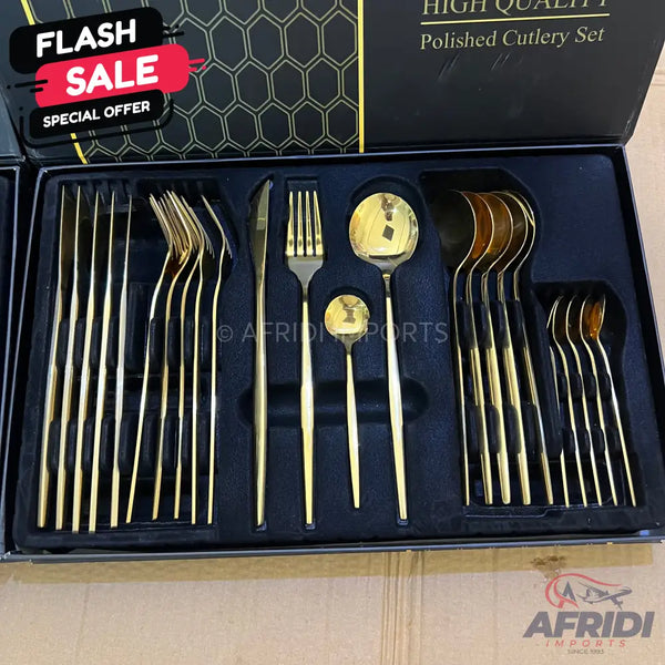 A gold-colored polished cutlery set in a black presentation box.