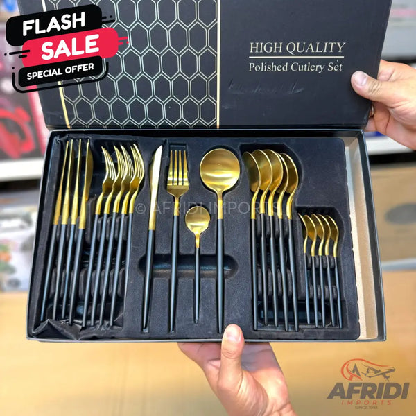 A black box containing a set of gold and black polished cutlery.