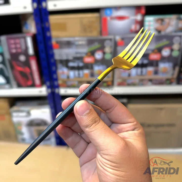 A gold-tined fork with a black handle.