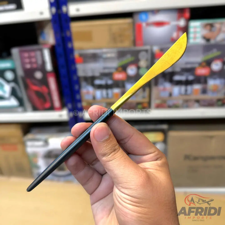 A butter knife with a dark handle and a golden-yellow blade.