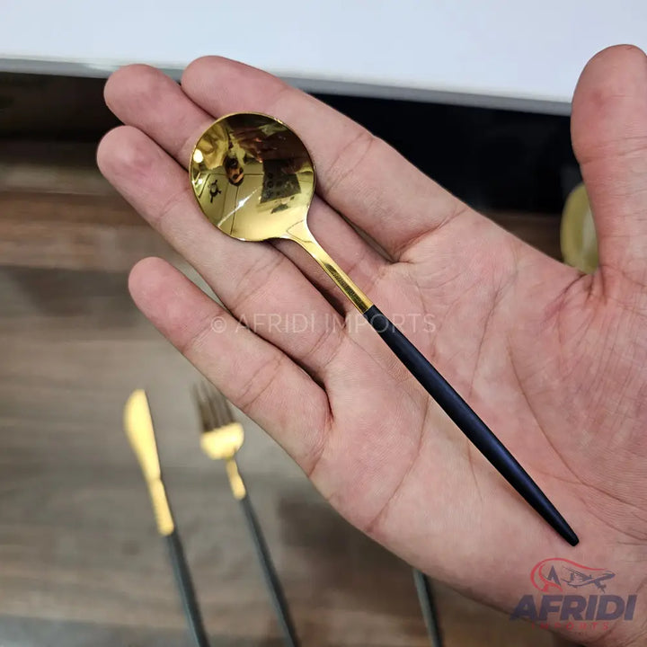 Gold-colored spoon with a black handle.