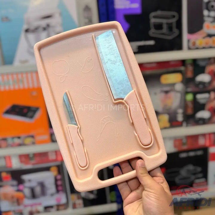 Pink plastic cutting board with two integrated knives.