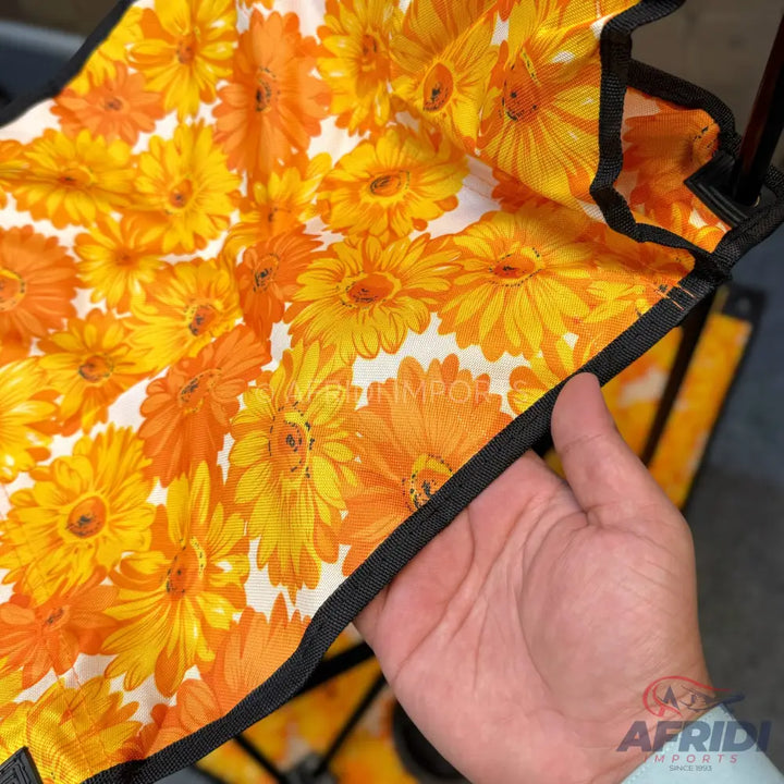 Orange and yellow floral patterned fabric with black trim.