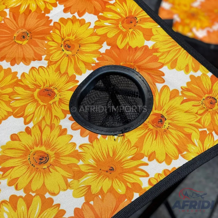Fabric with a pattern of orange and yellow daisy-like flowers and a black mesh cup holder.