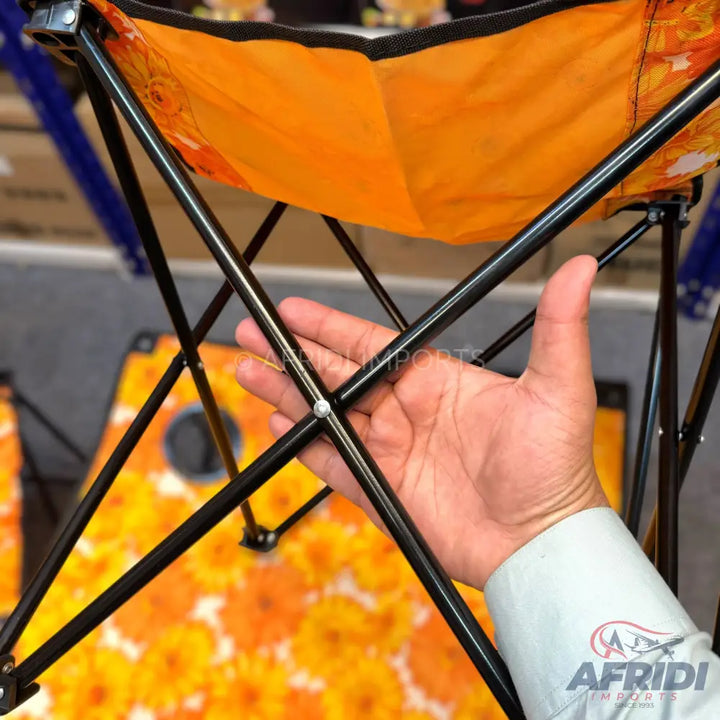 Black-framed portable folding chair with an orange fabric seat.