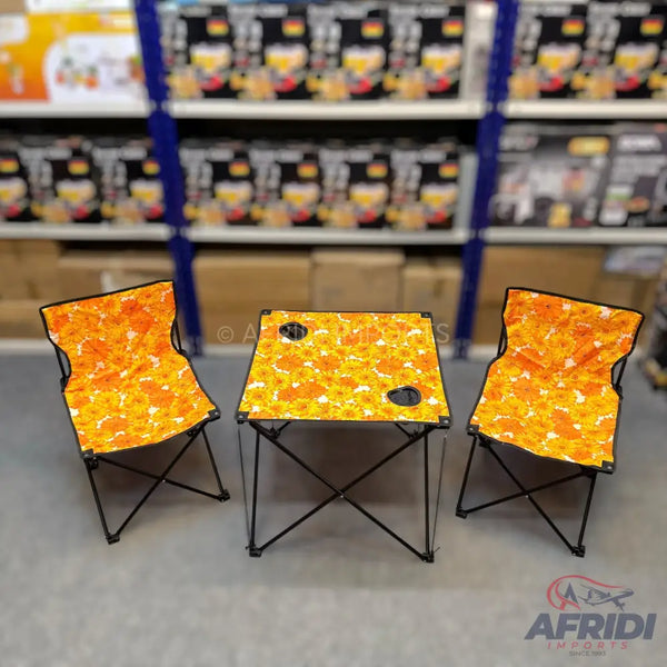 Portable camping table and two chairs set with a vibrant orange and yellow floral pattern.