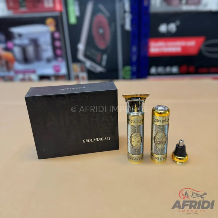 A black ’Grooming Set’ box and two ornate, gold and silver colored electric trimmers with an additional nose hair trimmer attachment.