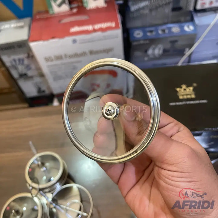 A clear glass lid with a metal rim and a central screw-on handle.
