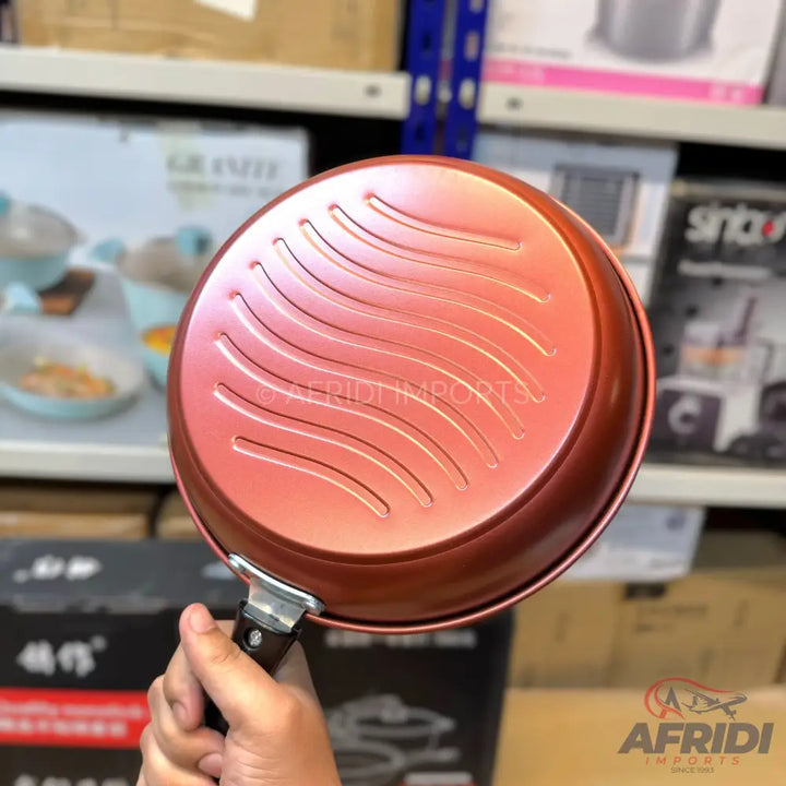 Copper-colored nonstick frying pan with a textured bottom.