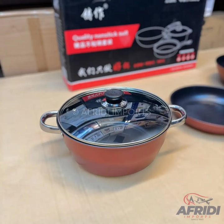 Red cooking pot with a glass lid and two handles.