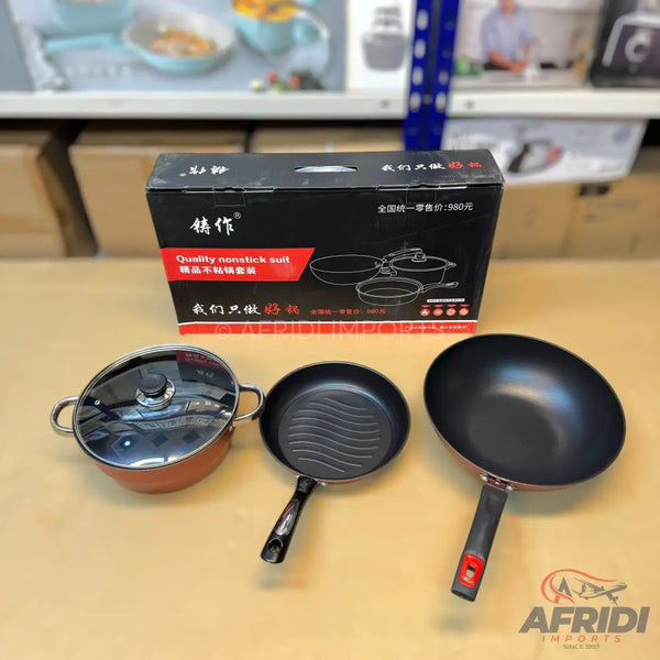 A set of black nonstick cookware including a lidded pot, a griddle pan, and a wok.