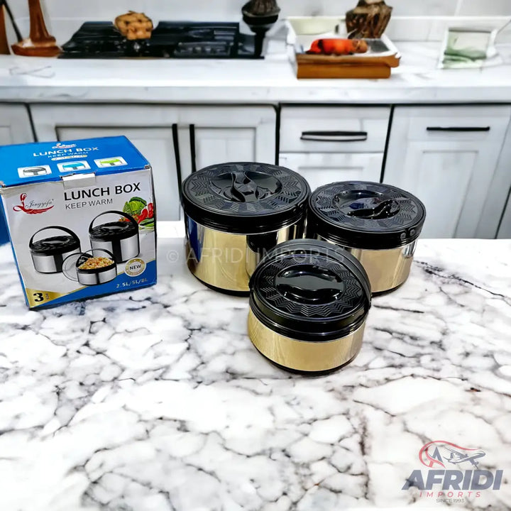 A set of three gold and black insulated lunch boxes.