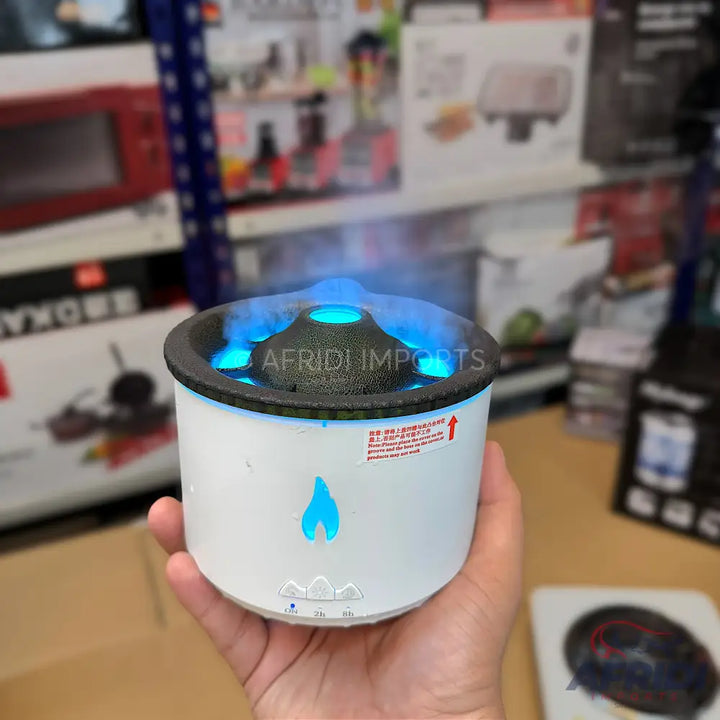 A white, volcano-shaped humidifier with blue LED lighting and a visible mist output.