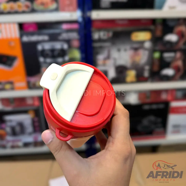 A red and white travel mug with an open lid.
