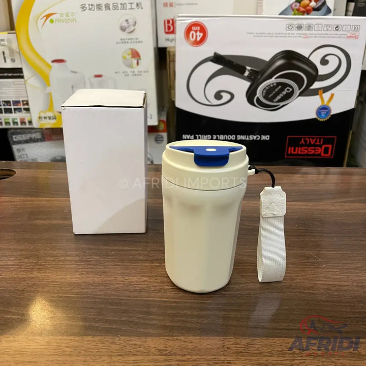 Cream-colored travel mug with a blue flip-top lid and a white wrist strap.
