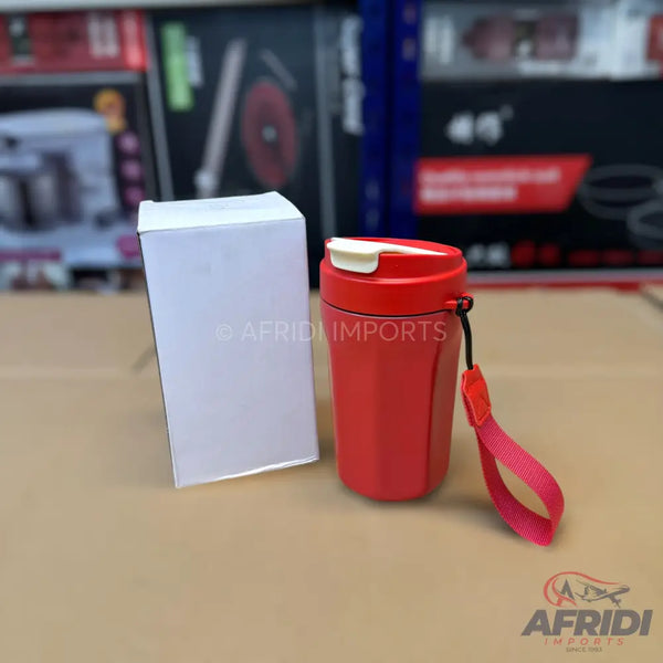 Red hexagonal travel mug with a white lid and a red wrist strap.