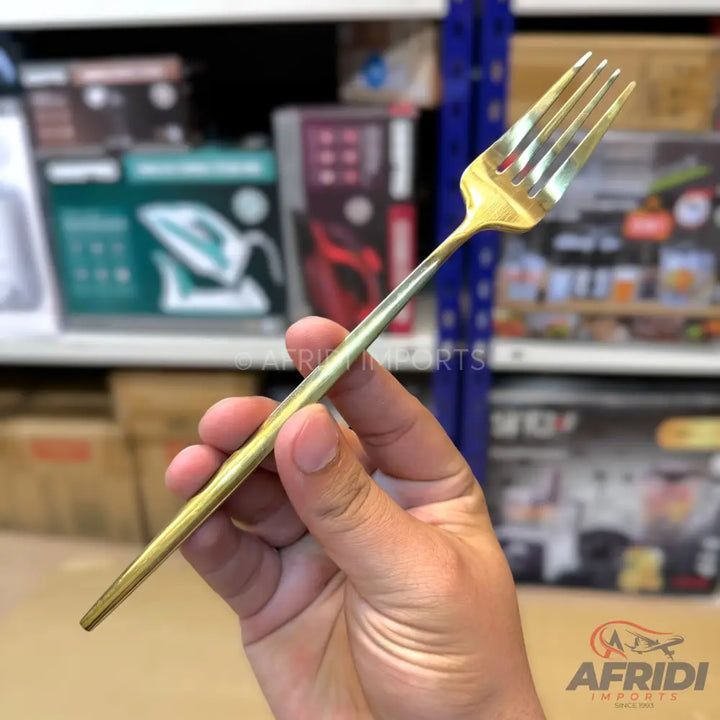 A shiny gold-colored metal dinner fork.