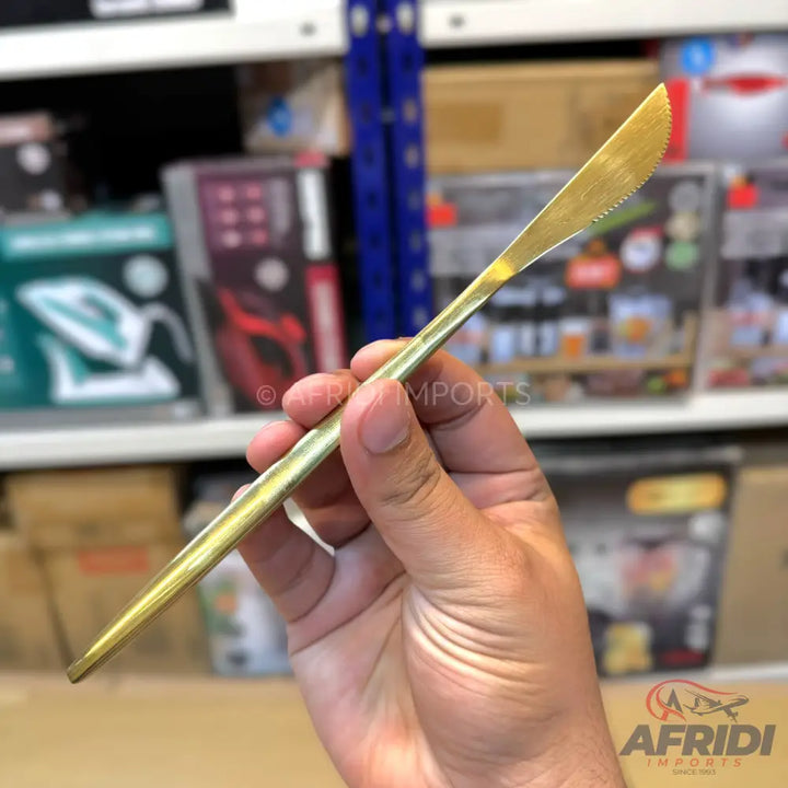 A golden serrated butter knife.