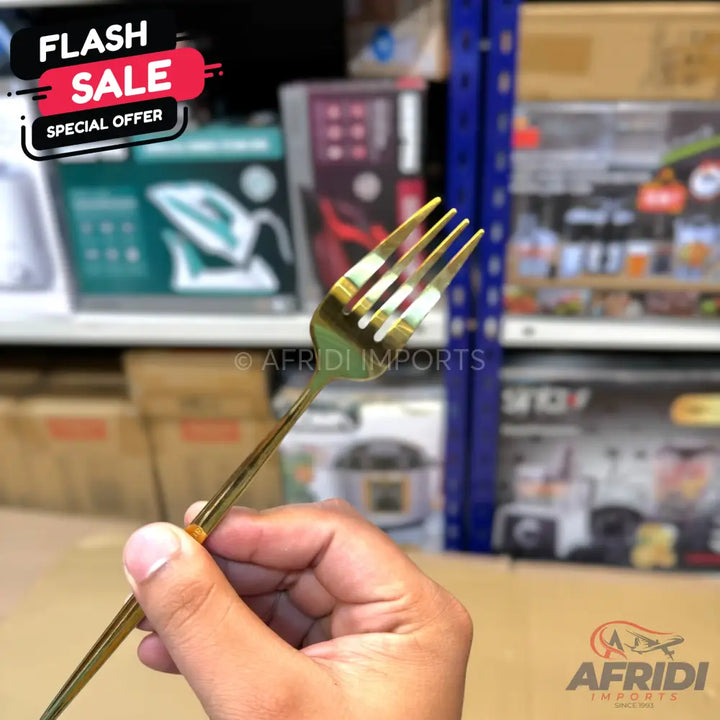 A shiny, gold-colored metal dining fork.