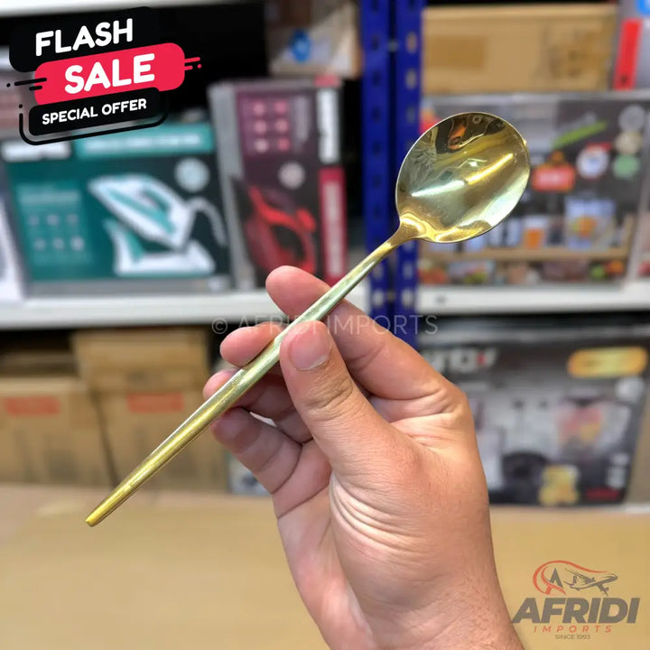 A gold-colored metal spoon with a slender handle.