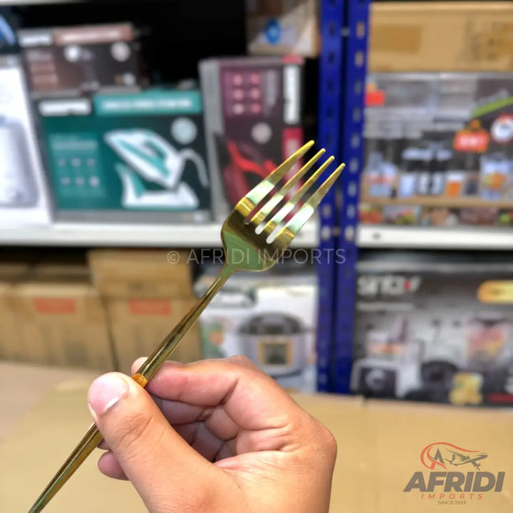 A shiny, gold-colored metal dining fork.