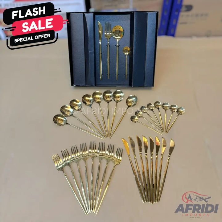 A comprehensive gold-colored cutlery set, including various spoons, forks, knives, and a boxed serving set.
