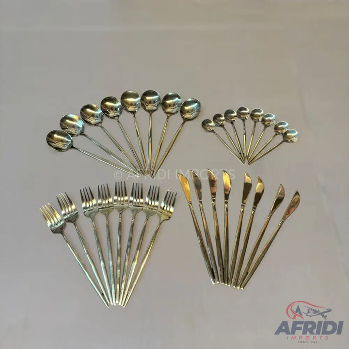 A set of shiny silver-colored spoons, forks, and knives arranged in fan patterns.