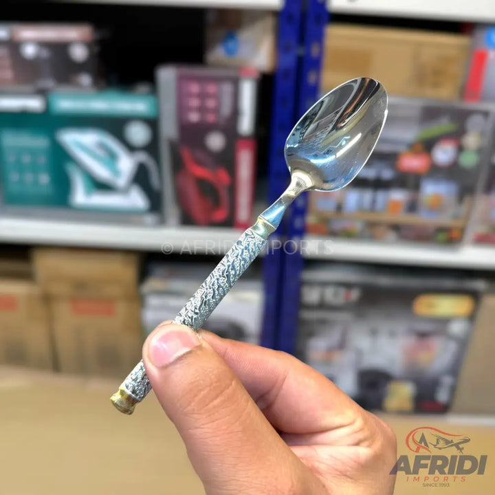 Silver-colored metal spoon with an ornate, textured handle.