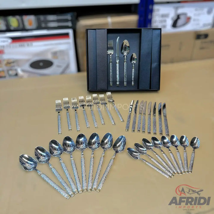 A stainless steel cutlery set with textured handles, including forks, knives, and spoons.