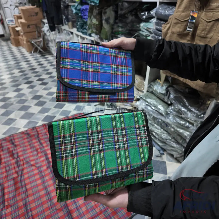 Two plaid folding picnic blankets, one blue and one green.