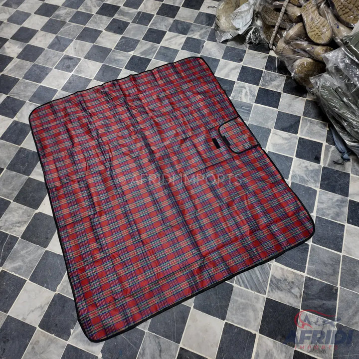 Red and blue plaid picnic blanket with a small pocket