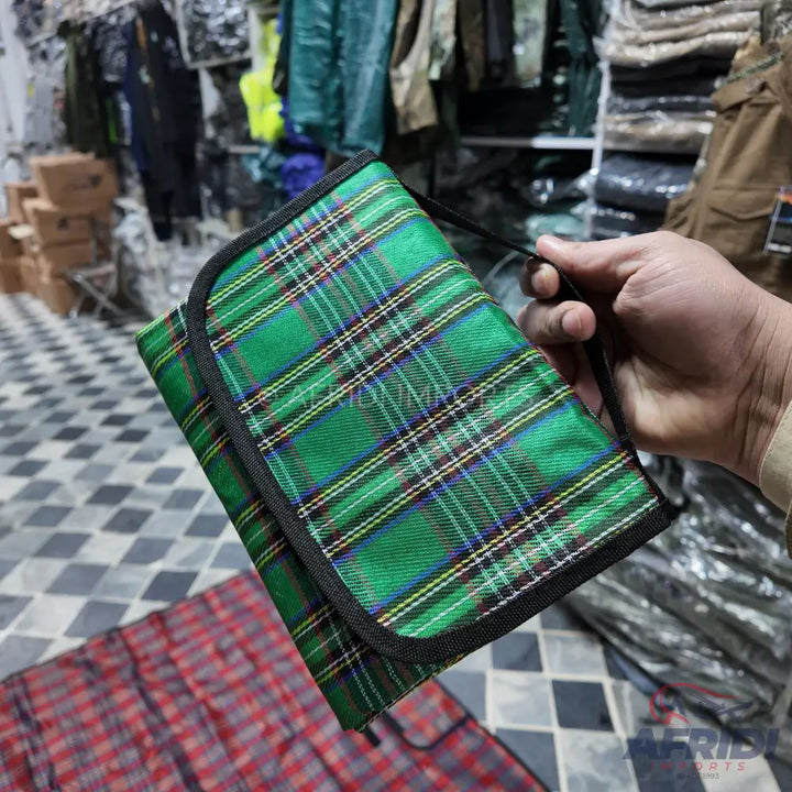 Green plaid fabric pouch with black trim.