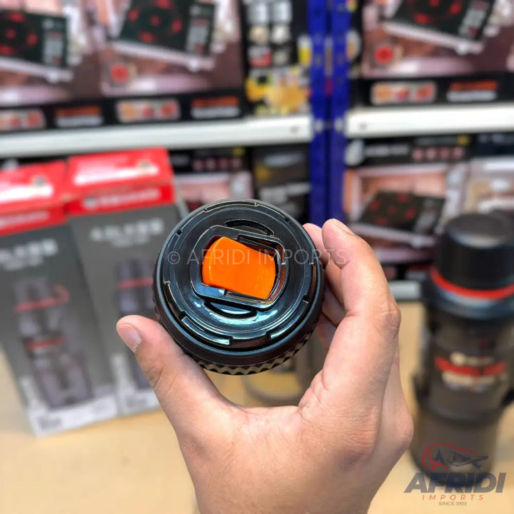 A black and orange portable electric coffee grinder.