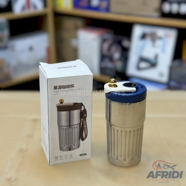 A stainless steel travel mug with a blue and white lid, packaged in a white box with an image of the mug and Chinese characters.