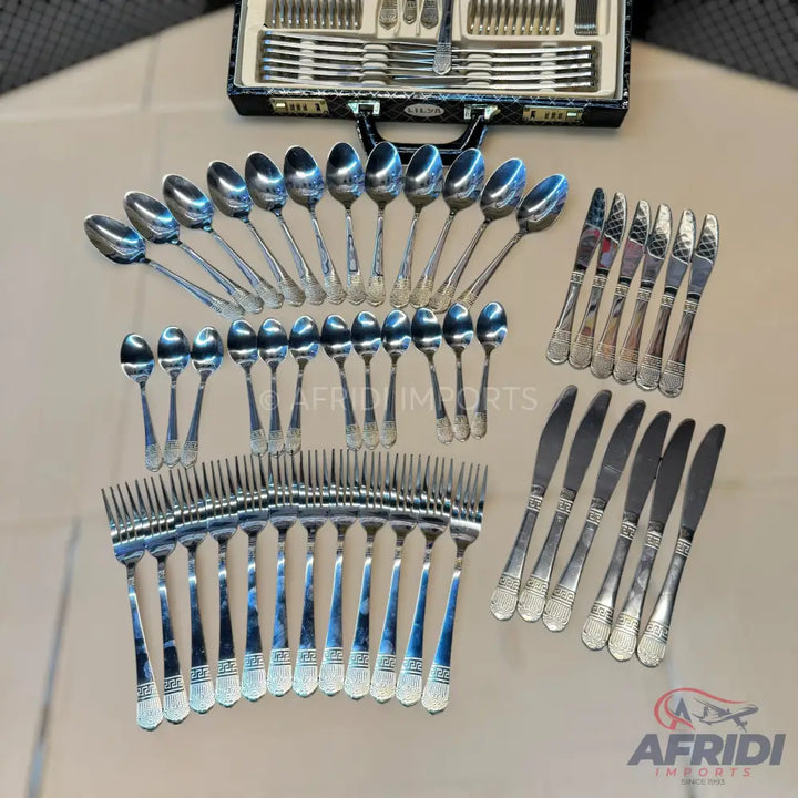 A large set of silver-colored flatware, including knives, forks, and spoons, with decorative handles.
