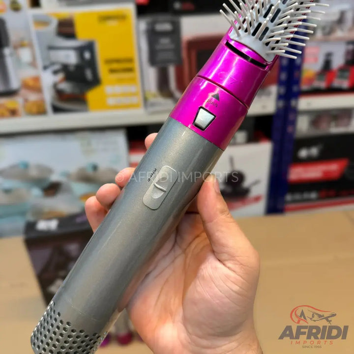 Pink and silver multi-functional hair styling tool with a brush attachment.