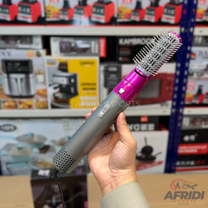 Handheld gray and magenta hot air brush with a round bristle head.