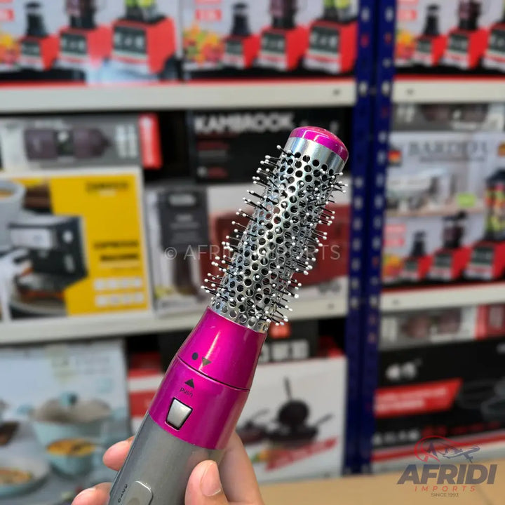 Pink and gray hot air brush with a round, vented barrel and bristles.