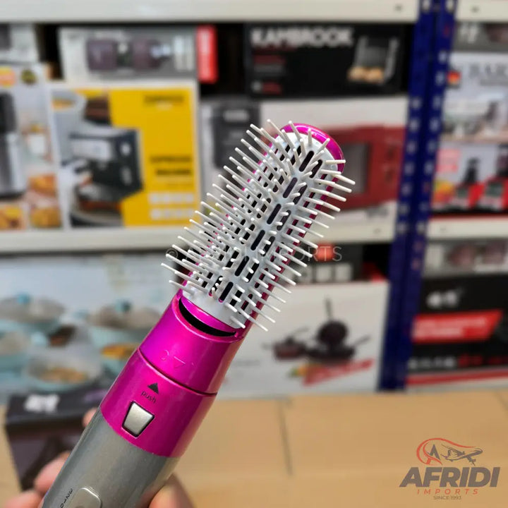 Pink and gray hot air brush with white bristles.