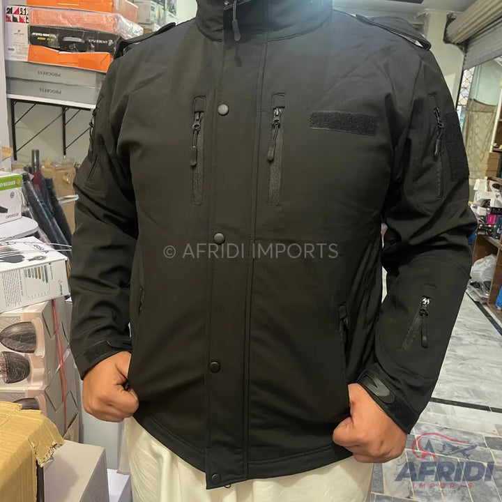 A black tactical jacket with multiple zippered pockets and button closures.