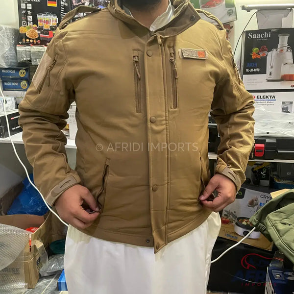 A tan, long-sleeved tactical jacket with multiple zippered pockets and button closures.