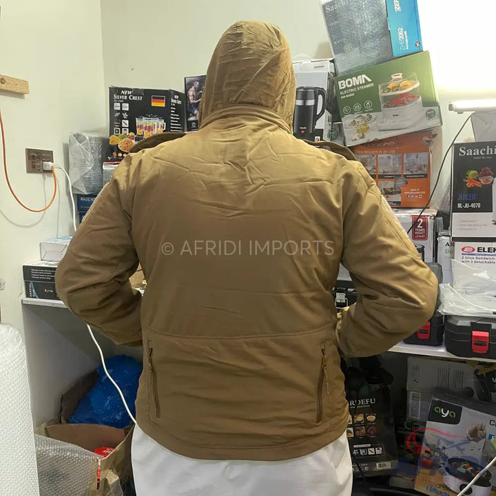 A tan hooded winter jacket with multiple zippered pockets.