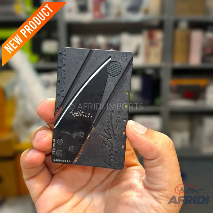 A black credit card-sized folding knife.