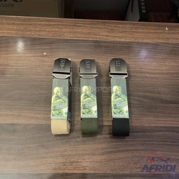 Three tactical canvas belts in beige, olive green, and black.